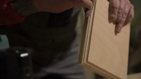 Carpenter stands behind the workplace, polishes with sandpaper, processes wood Stock Footage 149123808