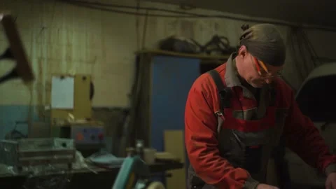 Carpenter stands behind workplace, processes wood using specialized equipment Stock Footage 149123737