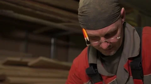 Carpenter stands behind workplace, processes wood using specialized equipment Stock Footage 149307893