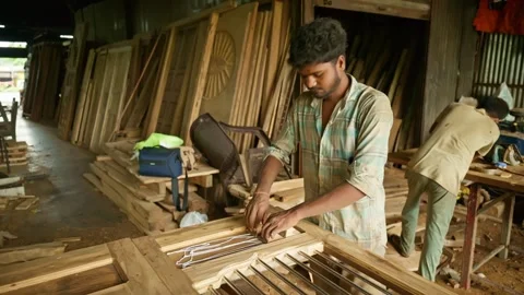 Carpenter stands in workshop focused on his task Stock Footage 301438038