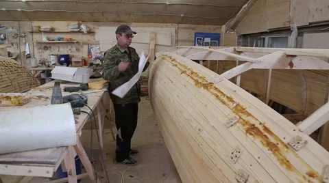 Carpenter studies the draft of the boat at the shipyard Stock Footage 59782438