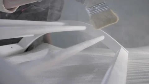 A carpenter sweeps away dust with a brush after polishing a wooden part. Video stock 232977652