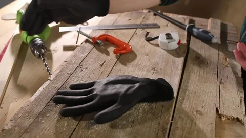 Carpenter takes off gloves in the workshop. finishing woodworking. close-up. Stock Footage 245983342