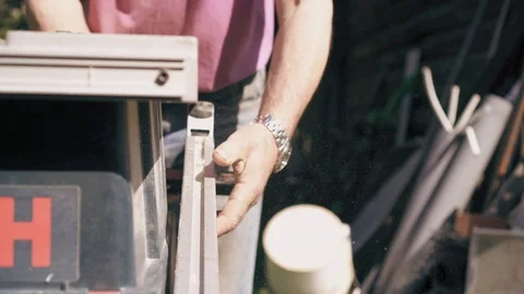 Carpenter is taking a professional equipment to stars work on circular saw. Man Stock Footage 90098144