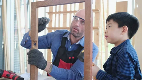 Carpenter teach kid to put hammer on frame Видео 144612032