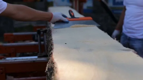 Carpenter throw away sawdust from board after cutting in sawmill. Close-up of Stock Footage 72698823