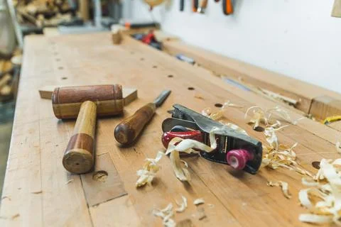 Carpenter tools - a wooden mallet, a chisel and a planer with wooden chips on Stock Photos
