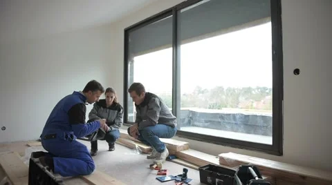Carpenter with trainees installing wooden floor Stock-Footage 45666324