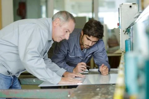 Carpenter trainees learning with boss about wood measurement Stock Photos