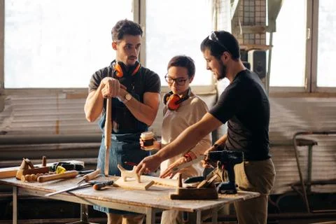 Carpenter Training Female Apprentice To Use Plane 스톡 사진