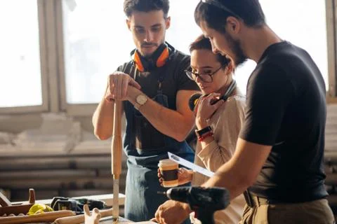 Carpenter Training Female Apprentice To Use Plane Stock Photos
