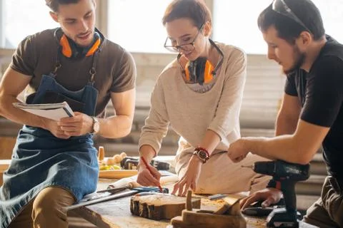 Carpenter Training Female Apprentice To Use Plane Foto stock