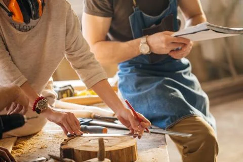 Carpenter Training Female Apprentice To Use Plane Stock Photos