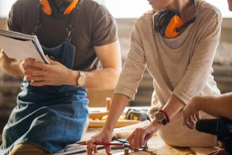 Carpenter Training Female Apprentice To Use Plane Stock Photos