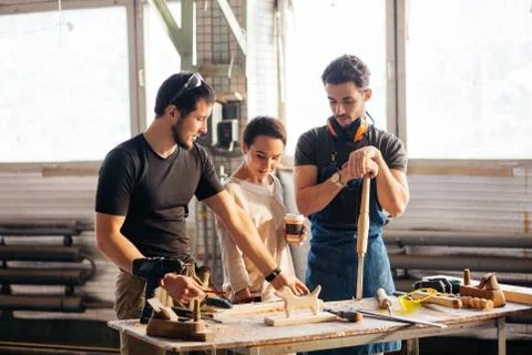 Carpenter Training Female Apprentice To Use Plane Foto stock