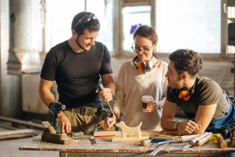 Carpenter Training Female Apprentice To Use Plane Stock Photos