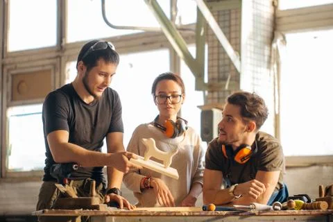 Carpenter Training Female Apprentice To Use Plane Stock Photos