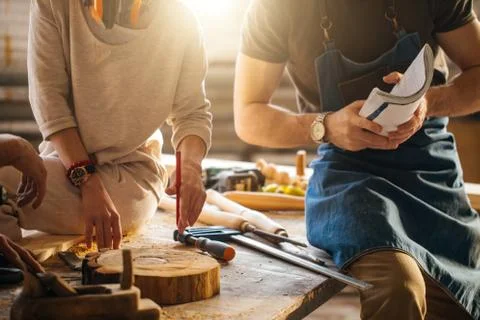 Carpenter Training Female Apprentice To Use Plane Stock Photos