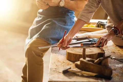 Carpenter Training Female Apprentice To Use Plane Stock Photos