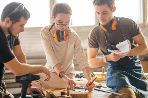 Carpenter Training Female Apprentice To Use Plane Stock Photos