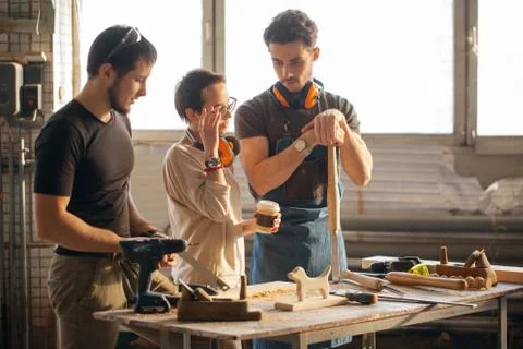 Carpenter Training Female Apprentice To Use Plane Stock Photos