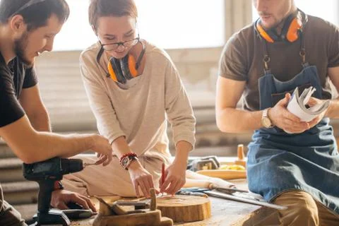 Carpenter Training Female Apprentice To Use Plane Stock Photos