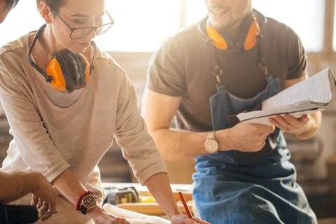 Carpenter Training Female Apprentice To Use Plane Stock Photos