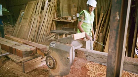 Carpenter trims lumber using safety gear and machine Stock Footage 310717788