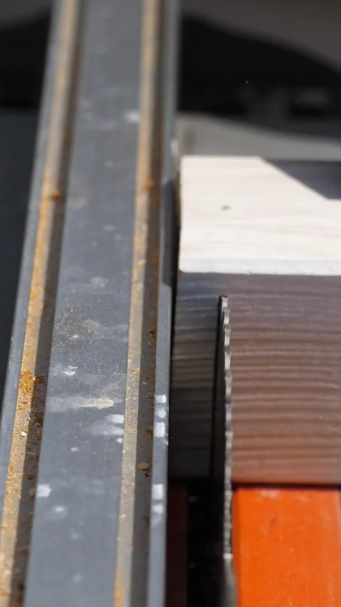 Carpenter trims a wooden block using a table saw outdoors Video stock 309835074