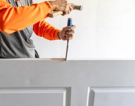 The carpenter use chisel for lock of door hinge. Stock Photos