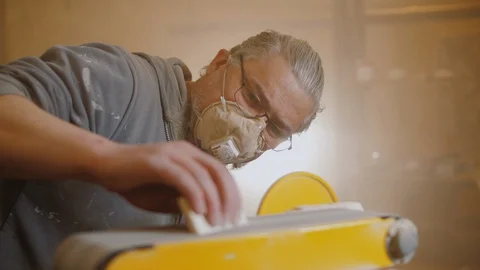 Carpenter use electric sander to polish wooden part of furniture Stock Footage 128750051