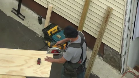 Carpenter uses Dewalt skill saw to cut plywood Revere Mass. USA March 15 2025 Stock Footage 304392881