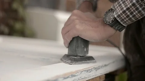 Carpenter uses electrical sander to sand wood in DIY project Stock Footage 94905394