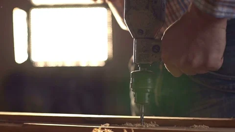 The carpenter uses a hand-held vintage drill in his work place. Slow motion Stock Footage 74013428