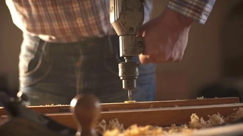 The carpenter uses a hand-held vintage drill in his work place. Slow motion Video stock 75774594