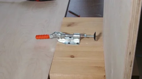 Carpenter uses metal clamp tool fixes plywood vertical position  Stock Footage 237372933