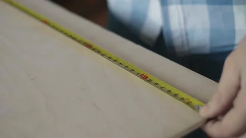 Carpenter uses roulette to measure for work Stock-Footage 153495450