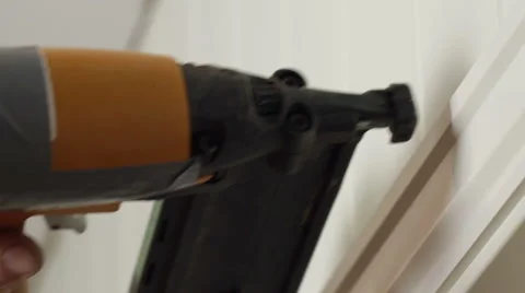 Carpenter uses a small nail gun on door molding Stock Footage 53063657