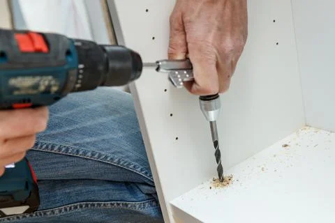 Carpenter using angle drilling bit adapter in furniture making process. Stock Photos