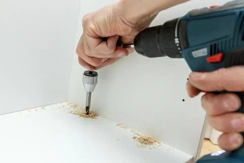 Carpenter using angle drilling bit adapter in furniture making process. Stock Photos