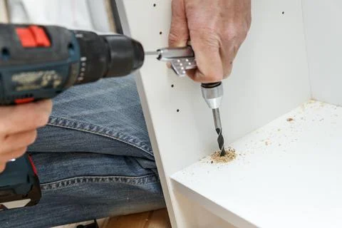 Carpenter using angle drilling bit adapter in furniture making process. Stock Photos
