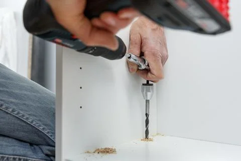 Carpenter using angle drilling bit adapter in furniture making process. Stock Photos