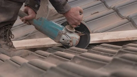Carpenter using an angle grinder to cut roof tiles Stock Footage 201940209