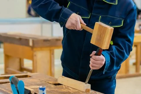 Carpenter using chisel and hammer to carve wood - close up Stock Photos