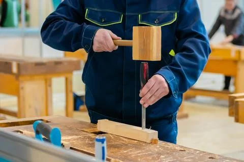Carpenter using chisel and hammer to carve wood - close up Stock Photos