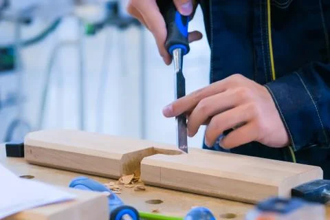 Carpenter using chisel to carve wood Stock Photos