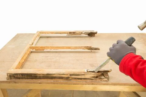 Carpenter using a chisel while repairing an old window sash Stock Photos