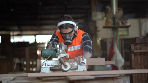 Carpenter using circular saw cutting wooden plank in workshop . Young man bui Stock Footage 149985263