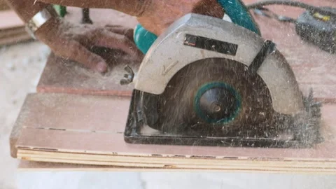 Carpenter using circular saw cutting wooden board in carpentry workshop Stock Footage 155982866