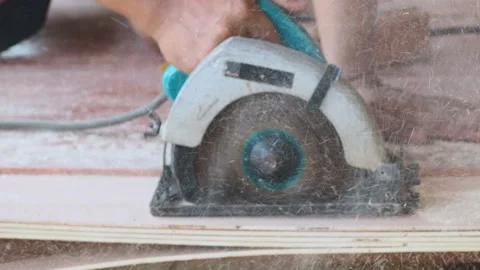 Carpenter using circular saw cutting wooden board in carpentry workshop Stock Footage 155982924